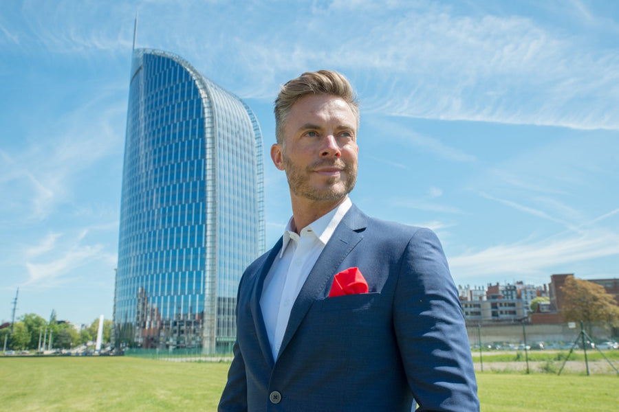 Man in donkerblauwe blazer met rode pochet