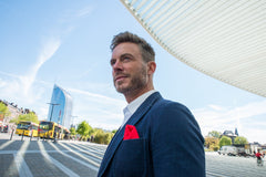 Man in blauwe blazer met rode pochet